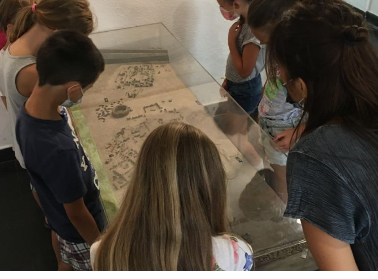 Gruppo di bambini in Museo davanti a un modellino della necropoli di Chiavari